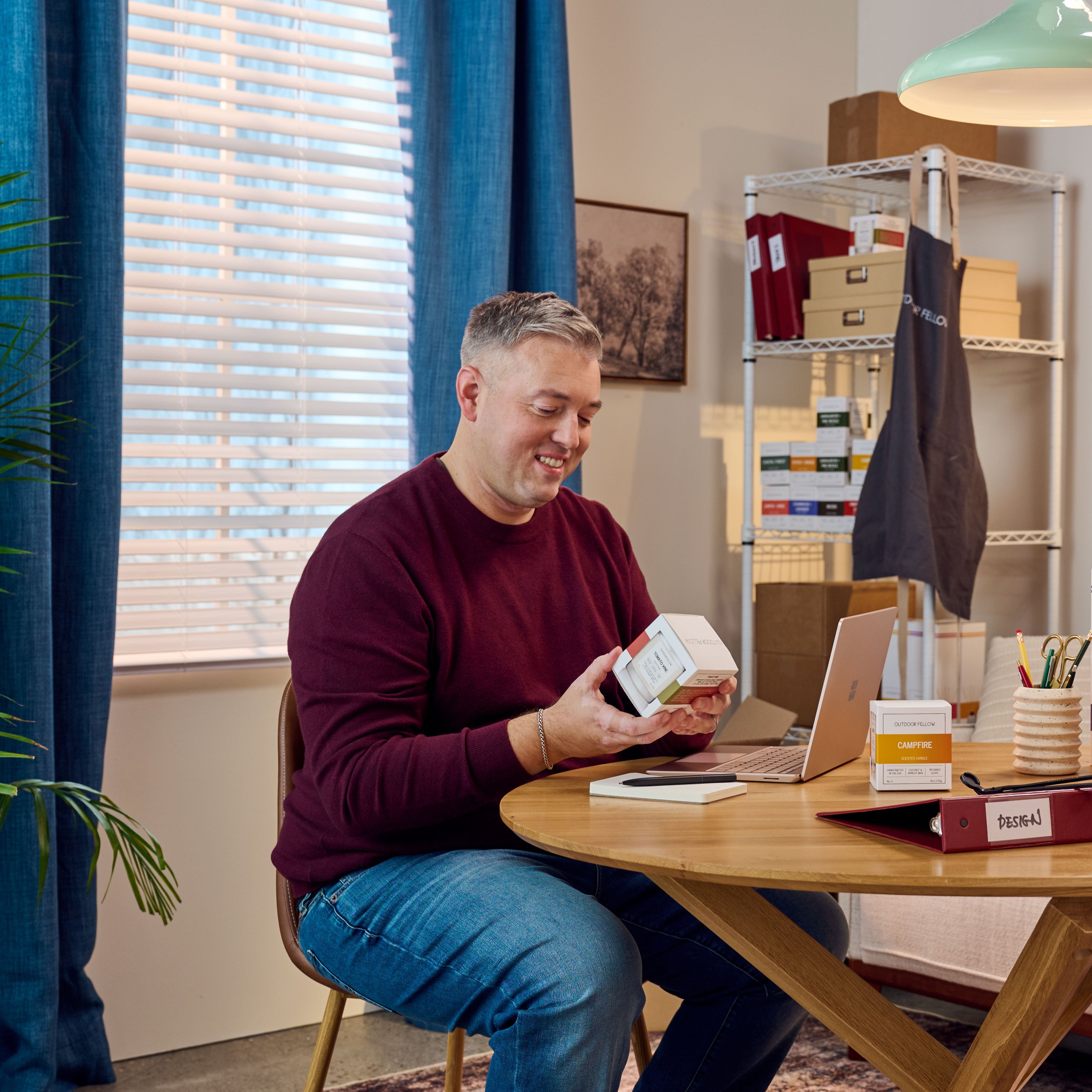 Patrick Jones, founder of Outdoor FEllow holding a candle at his desk
