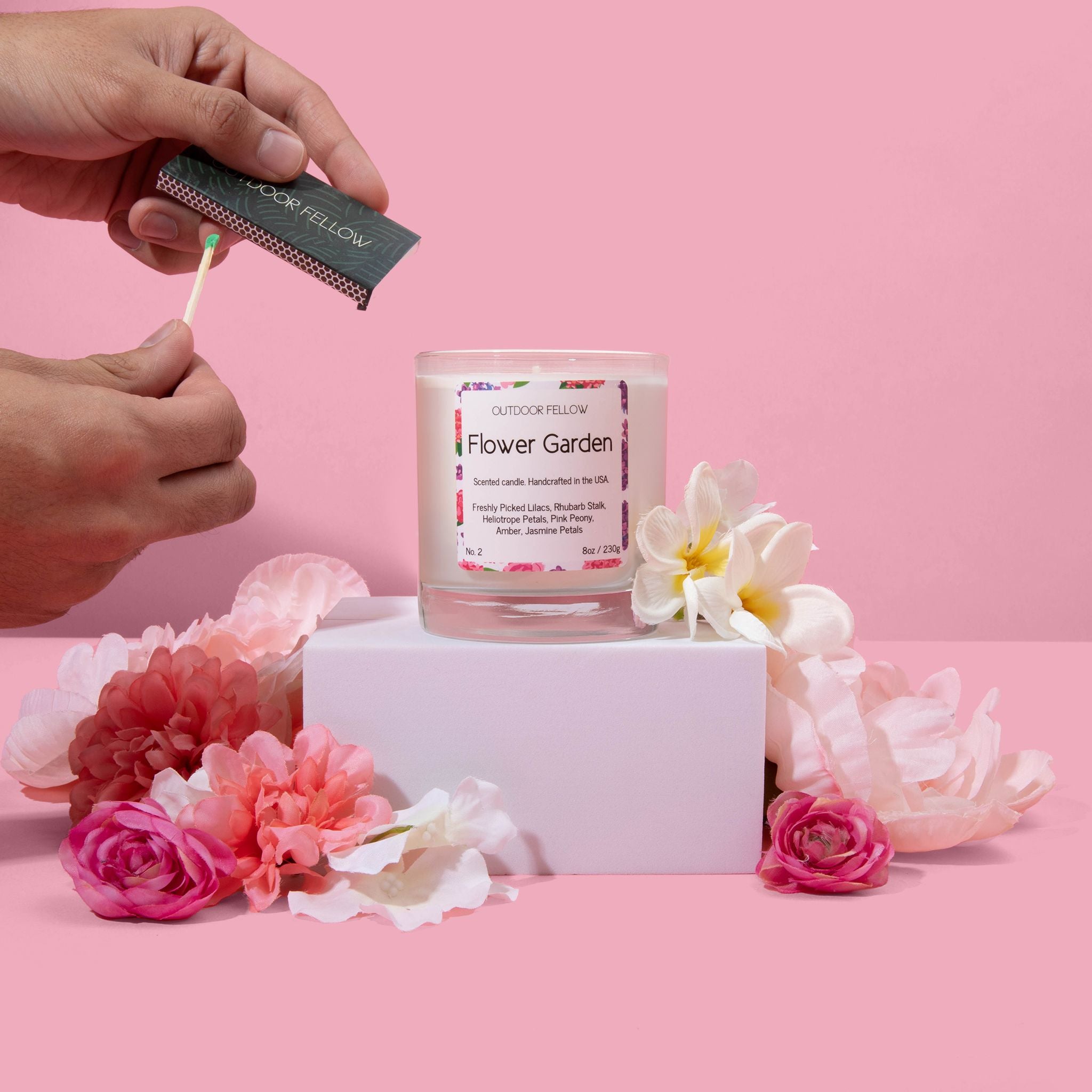Flower Garden scented candle surrounded by flowers about to be lit