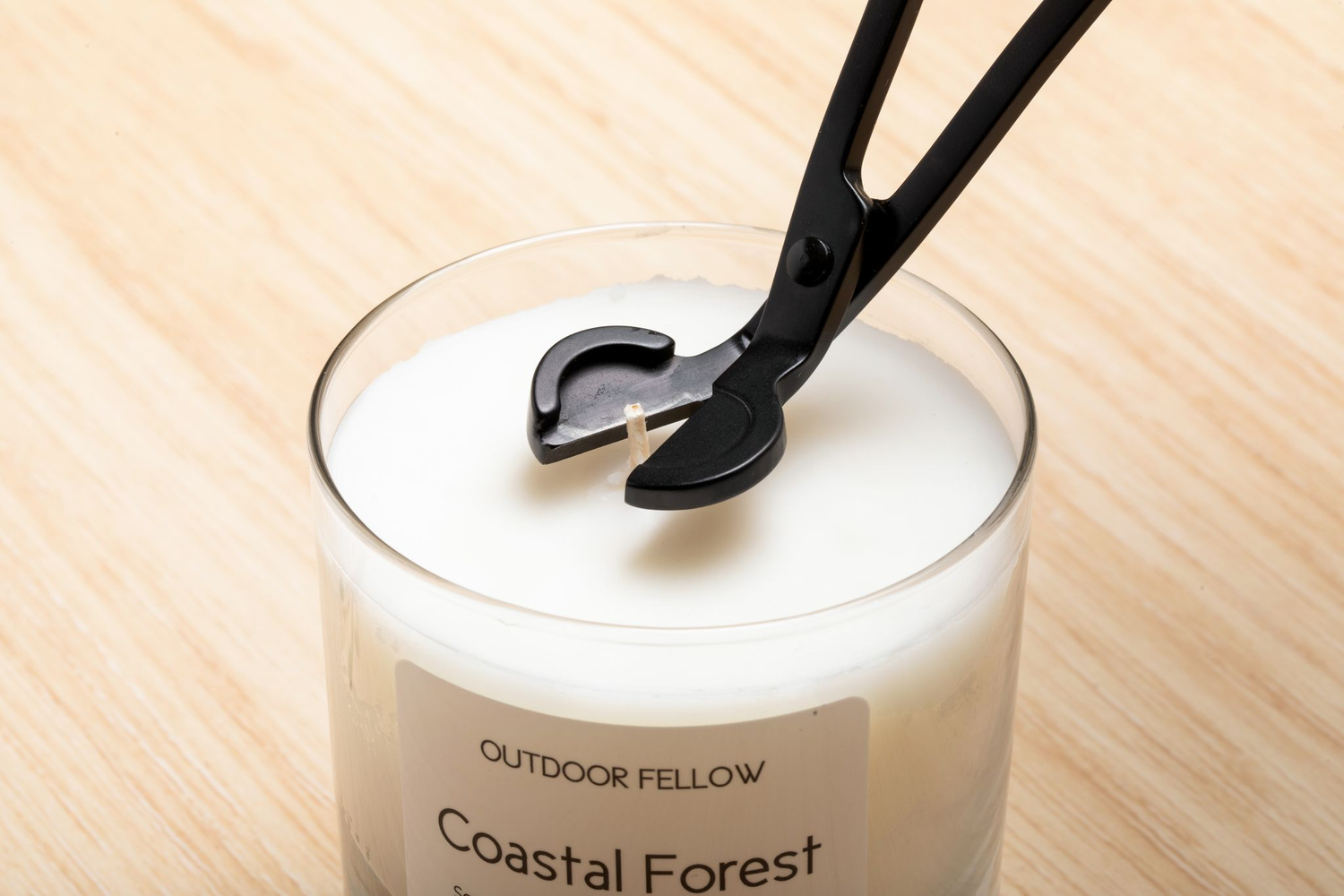 Wick trimmer cutting a wick on a candle