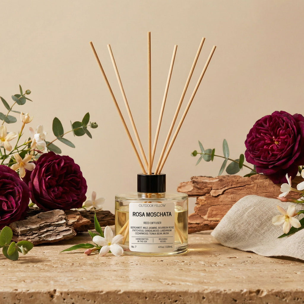 Rosa Moschata diffuser with flowers and wood on a wooden surface