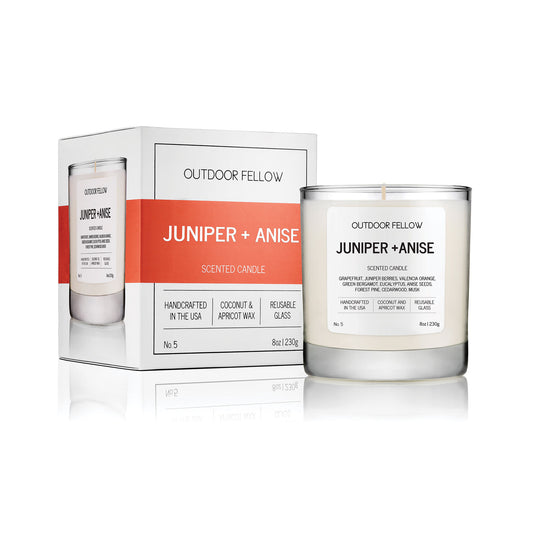 Juniper and Anise scented candle with product packaging on a white background