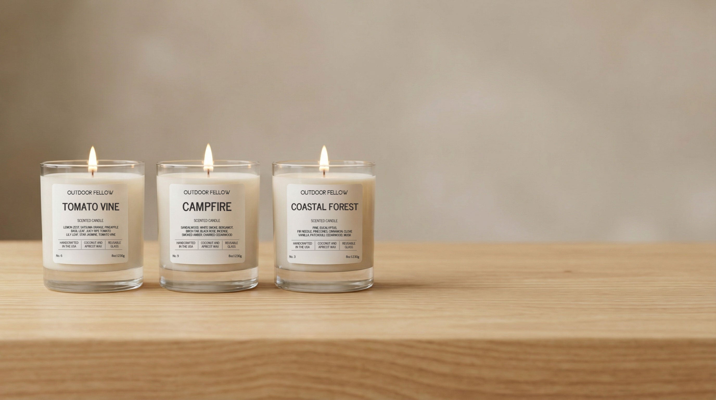 Three candles with labels on a wooden surface and neutral background