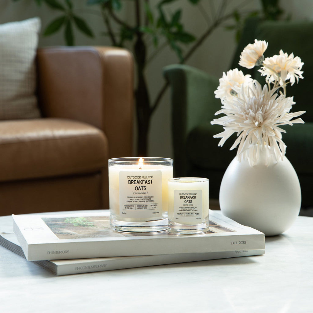 Candle and vase on a table with a blurred background of a living room.