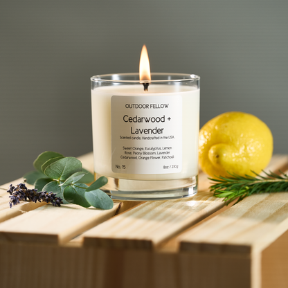 Cedarwood and Lavender scented candle on a wooden crate surrounded by lavender, eucalyptus and lemon
