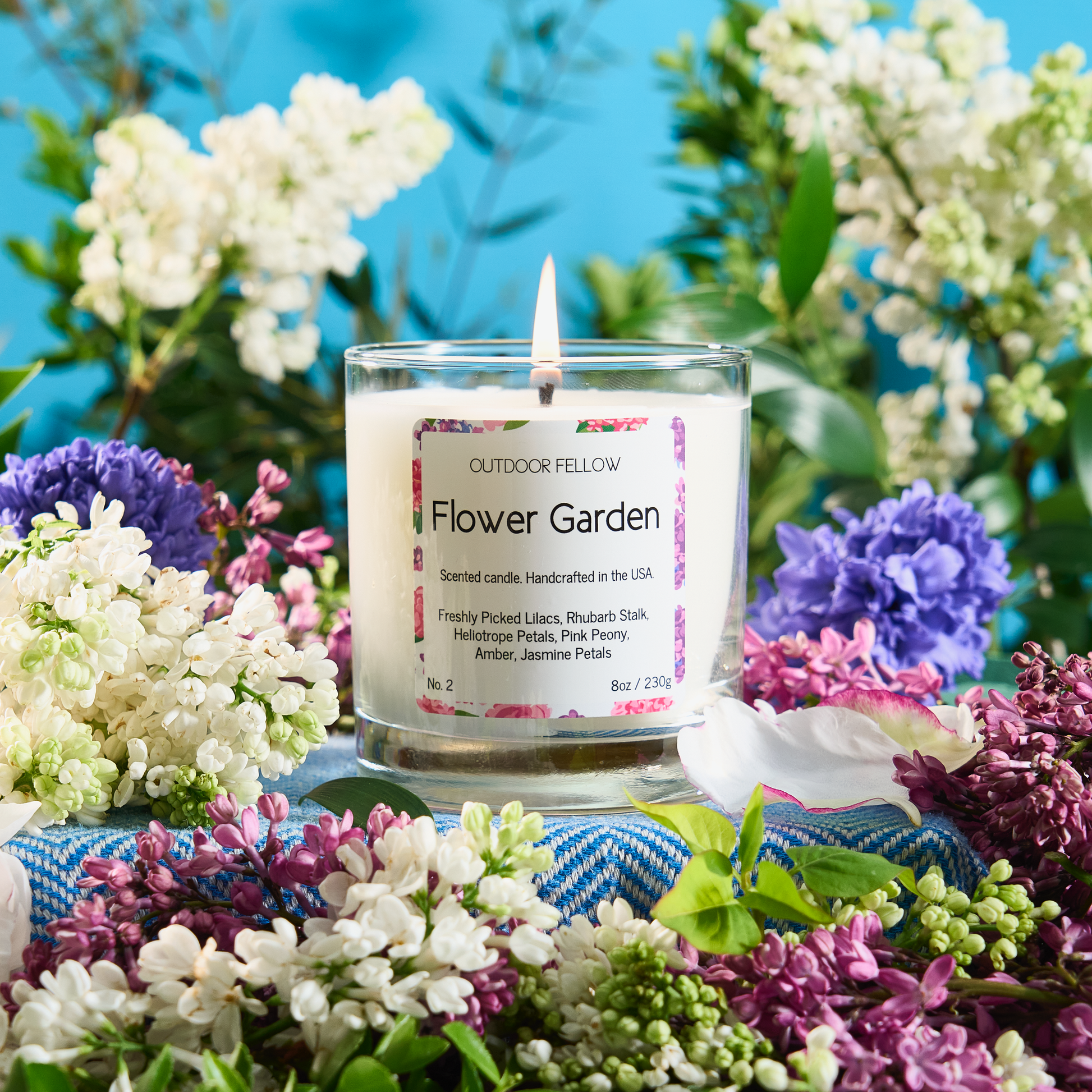 Flower Garden scented candle surrounded by lilac flowers