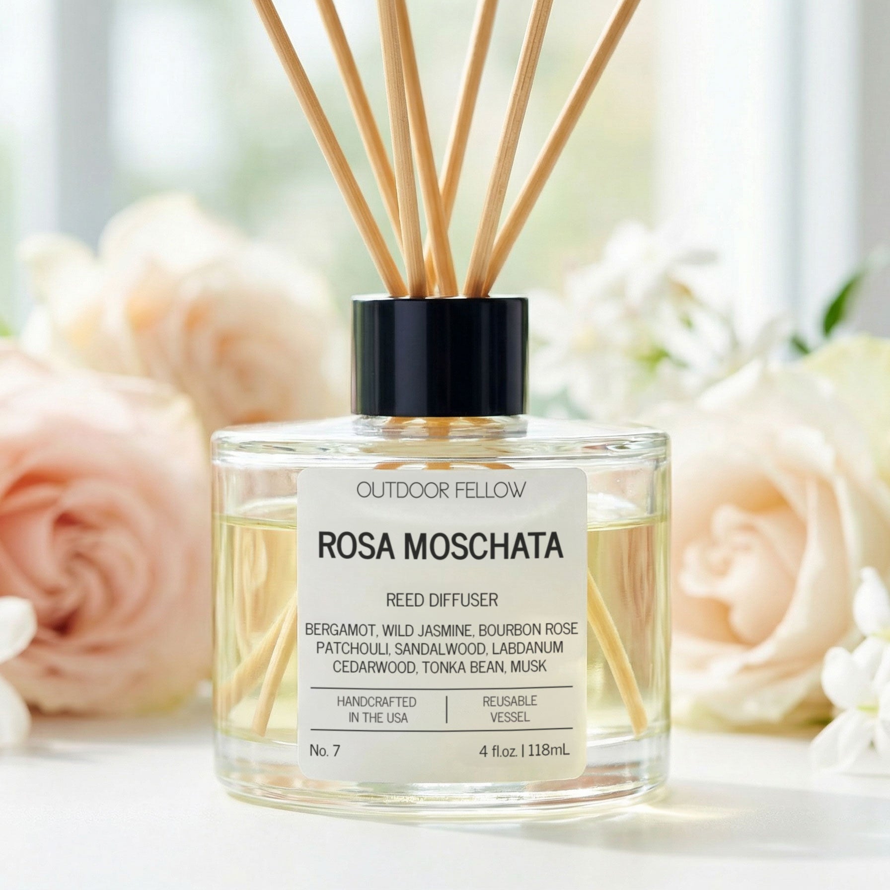 Rosa Moschata reed diffuser with flowers in the background
