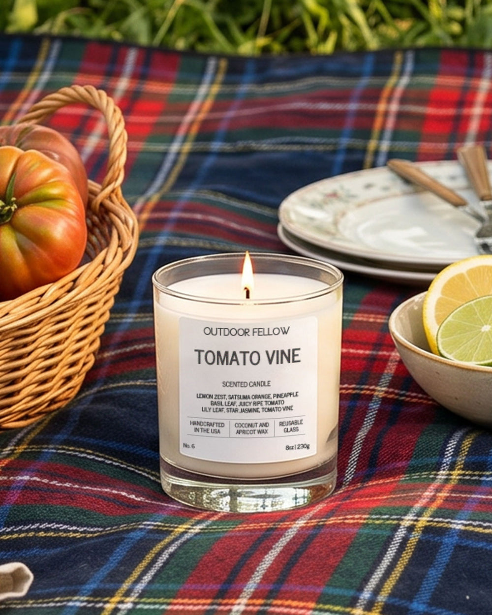 Outdoor Fellow Tomato Vine candle on a plaid blanket with tomatoes and lemons.