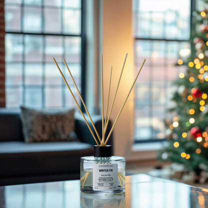 Winter Fir reed diffuser on a living room table with a Christmas tree and couch in the background. 