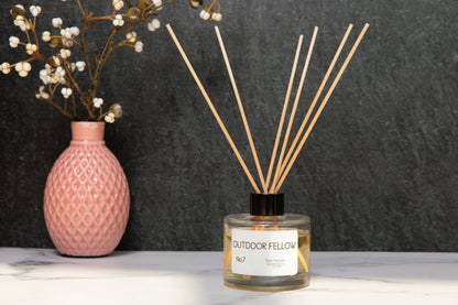 No.7 Rosa Moschata reed diffuser next to pink vase with white flowers