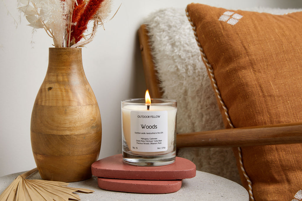 Woods candle on side table next to wooden vase